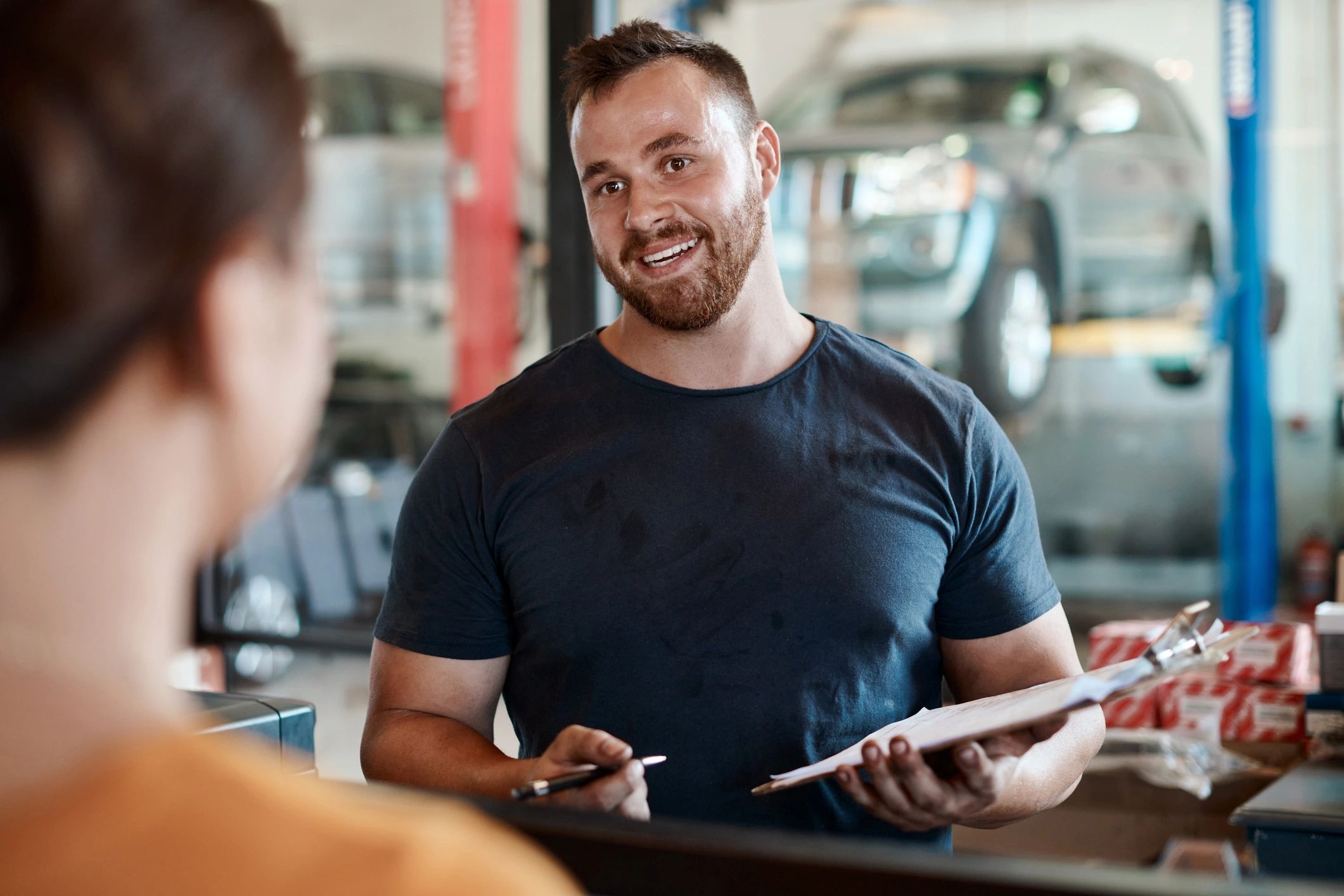 Service advisor speaking with a customer at an auto repair shop counter