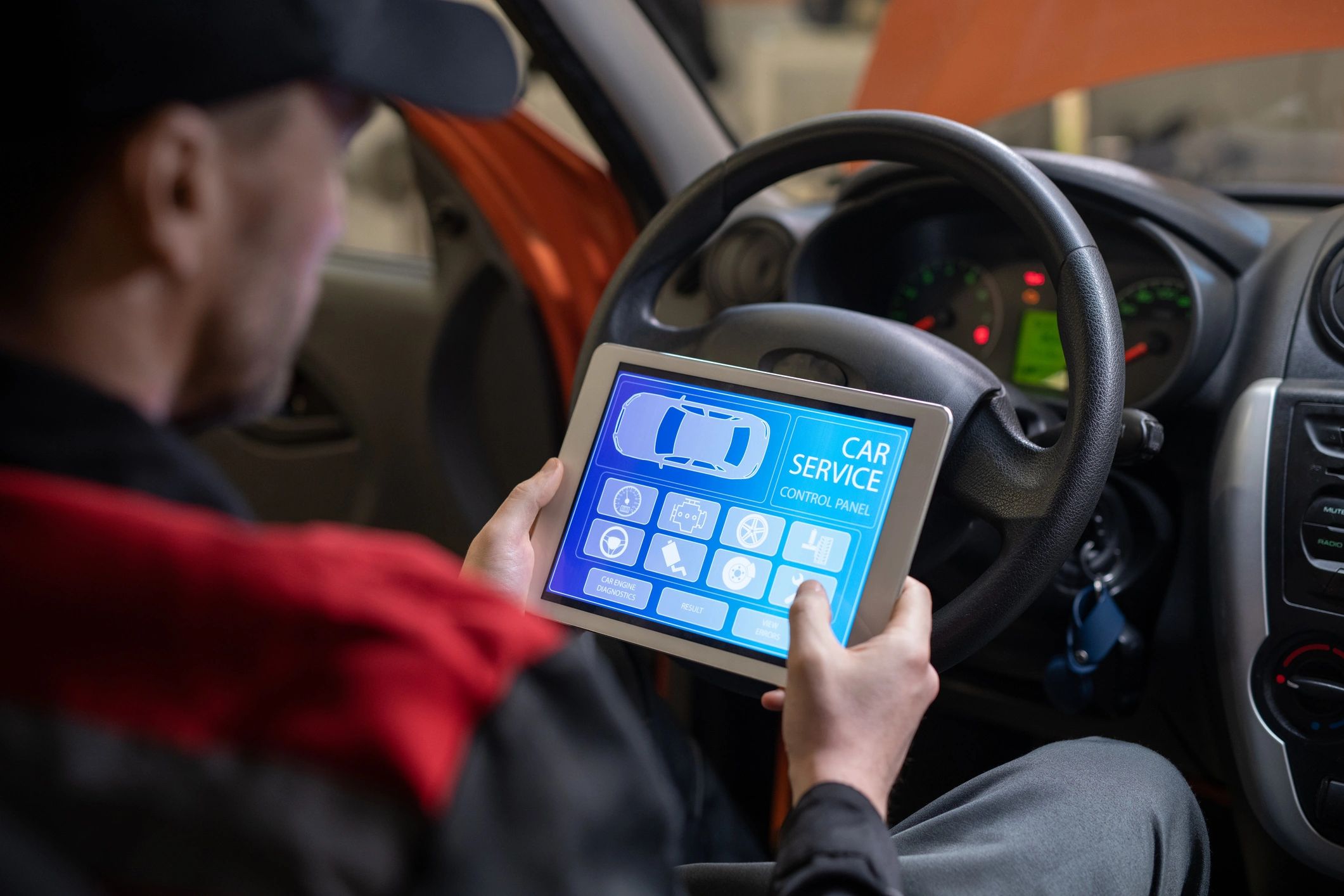Mechanic performing a diagnostic check using a digital device