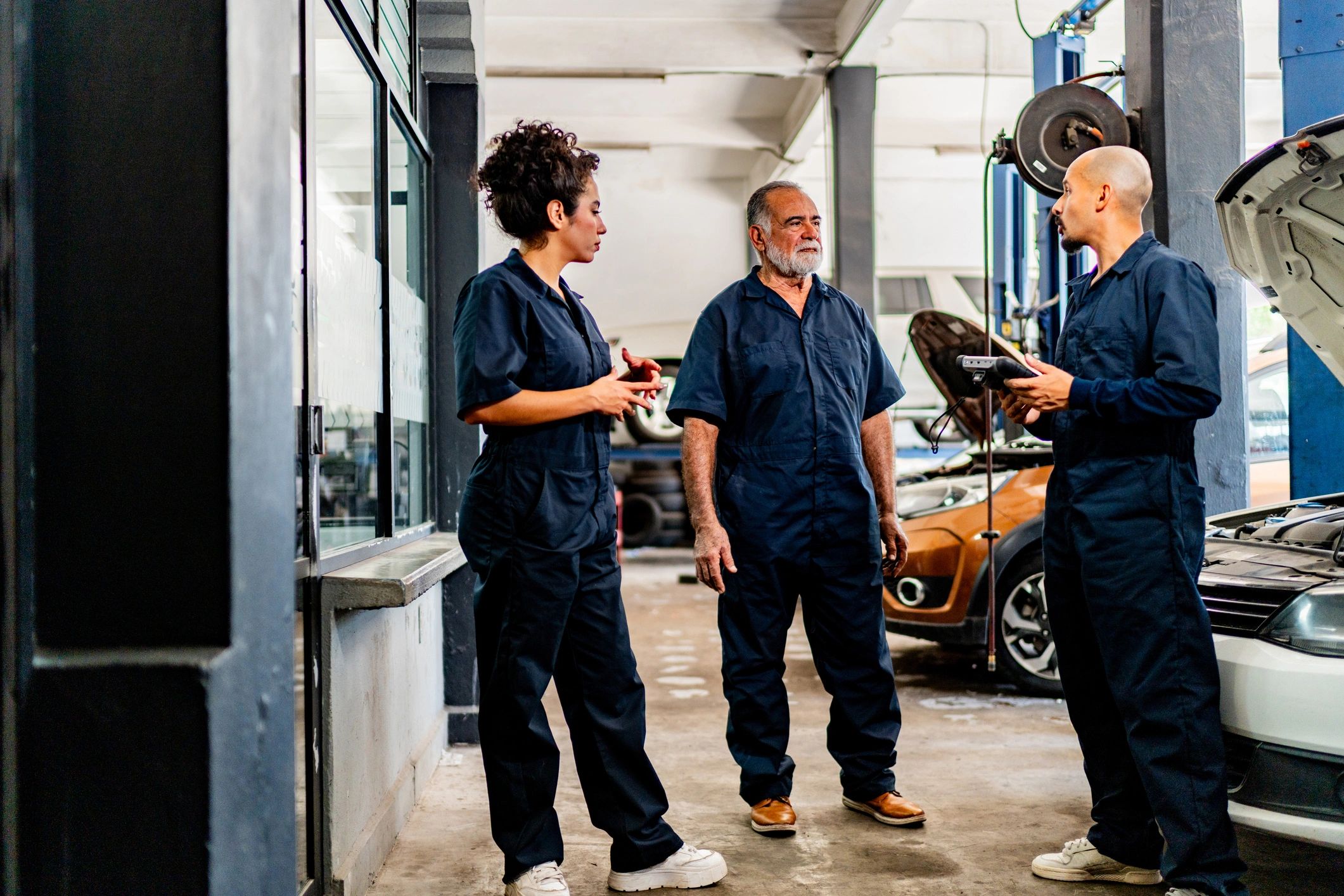 Technicians discussing a repair plan in an auto shop